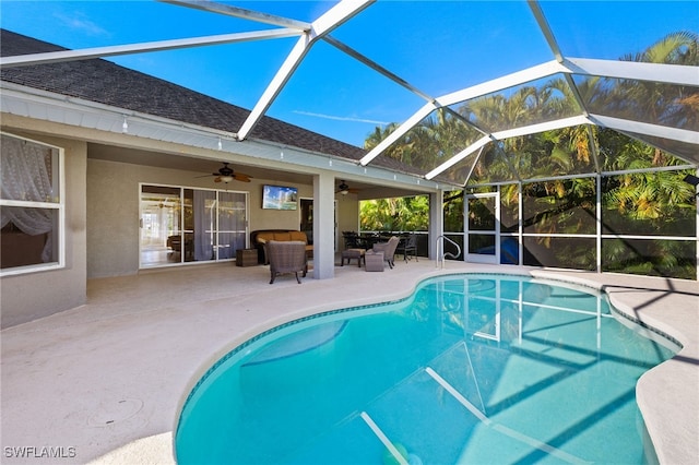 view of swimming pool with ceiling fan, an outdoor hangout area, glass enclosure, and a patio area