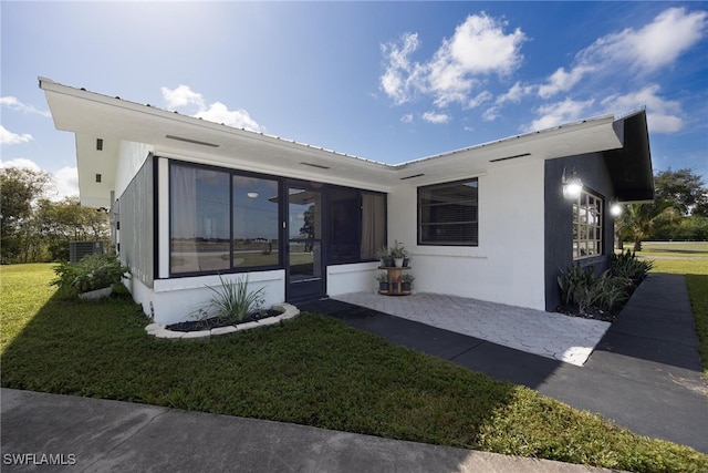 exterior space with a yard and a sunroom