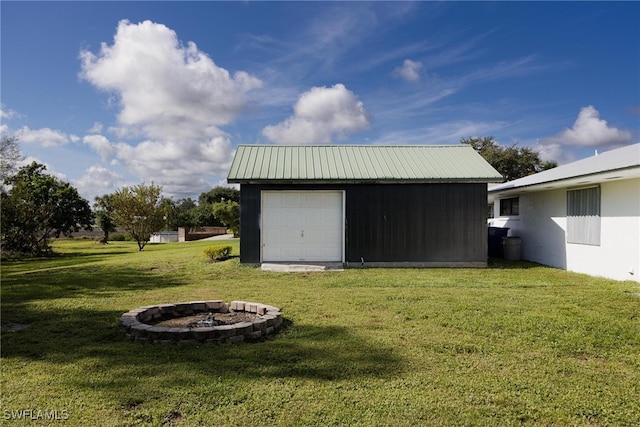 exterior space with a yard, a fire pit, and a garage