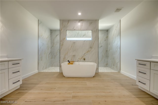 bathroom with wood-type flooring, shower with separate bathtub, and vanity