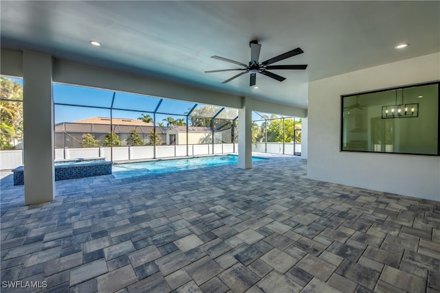 view of swimming pool with ceiling fan, glass enclosure, a patio, and an in ground hot tub