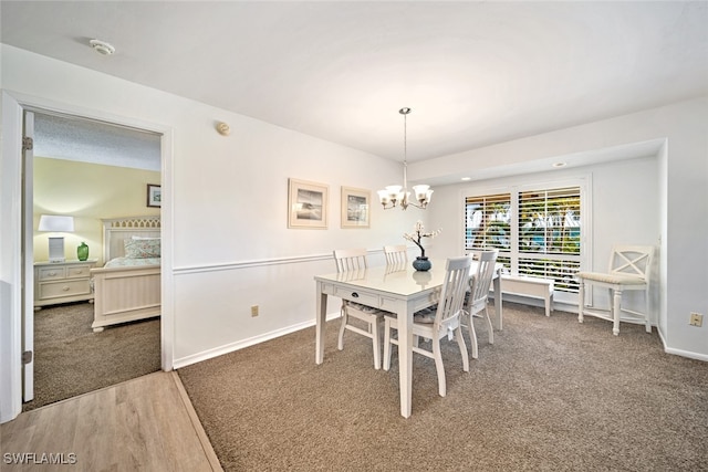 dining room with dark carpet and a chandelier