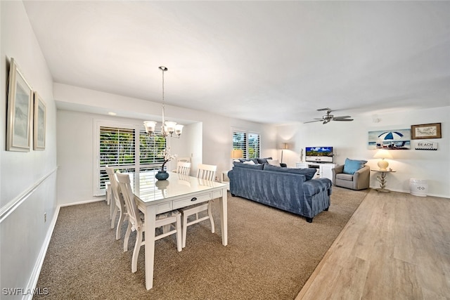 dining area with wood-type flooring and ceiling fan with notable chandelier