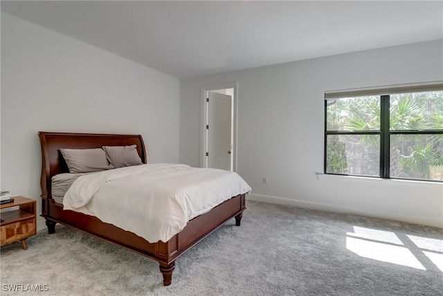 bedroom featuring baseboards and light colored carpet