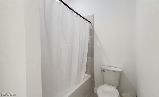 full bath featuring toilet and shower / tub combo with curtain