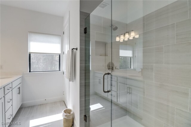 bathroom featuring a shower stall, vanity, and baseboards