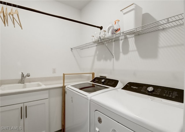 laundry room featuring cabinet space, separate washer and dryer, and a sink