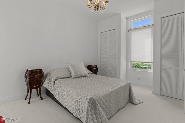 carpeted bedroom with multiple windows, two closets, and a notable chandelier