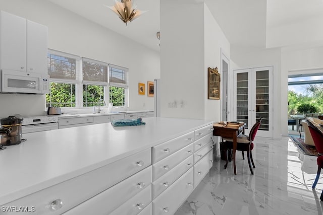 kitchen featuring white appliances and white cabinetry