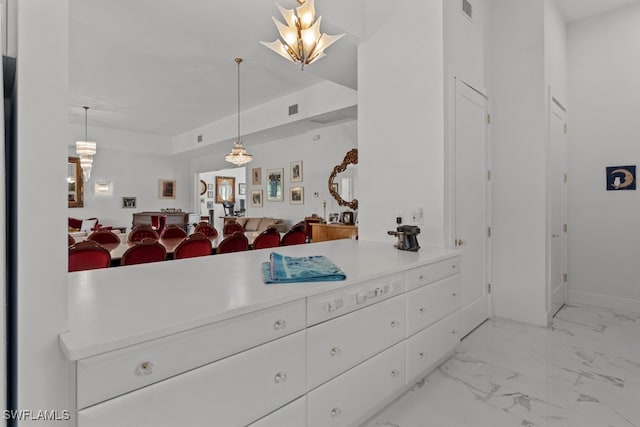 kitchen with white cabinets and hanging light fixtures