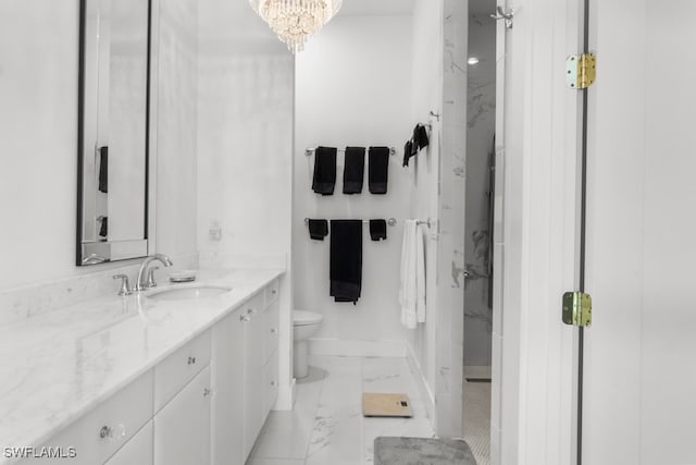 bathroom with vanity, a notable chandelier, and toilet