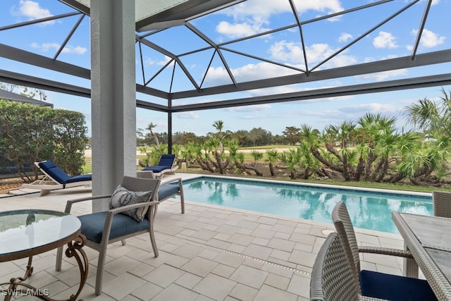 view of swimming pool featuring a patio area and glass enclosure