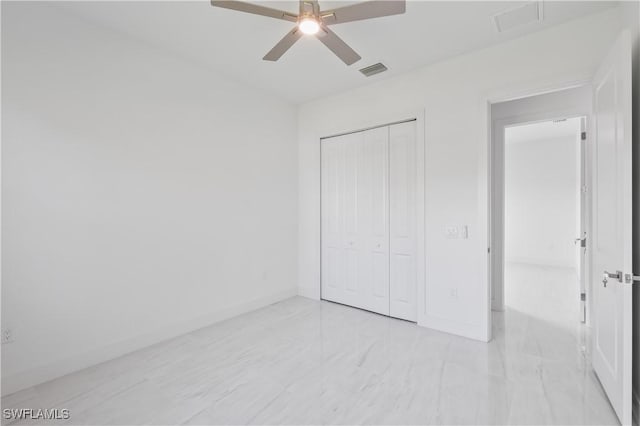 unfurnished bedroom with ceiling fan and a closet