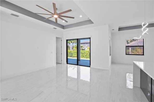 unfurnished room with a tray ceiling and ceiling fan