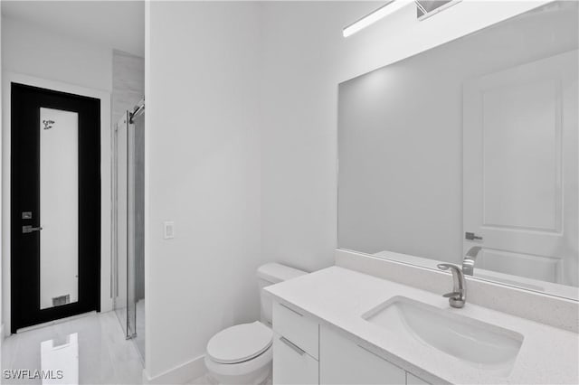 bathroom featuring vanity, toilet, and a shower with shower door