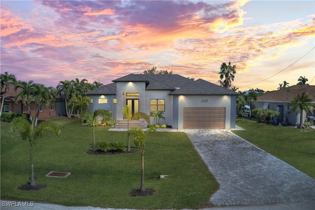 view of front of property with a yard and a garage