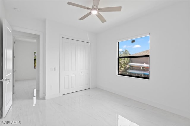 unfurnished bedroom featuring ceiling fan and a closet