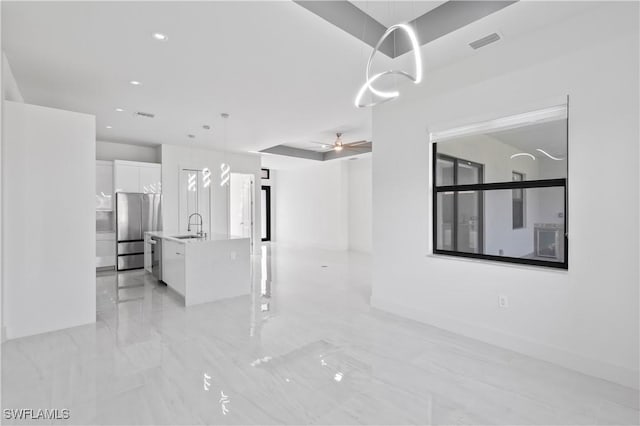 unfurnished living room with ceiling fan and sink