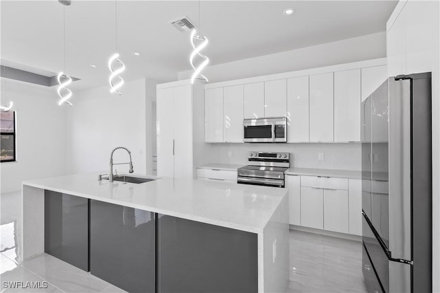 kitchen with decorative light fixtures, sink, white cabinetry, and stainless steel appliances