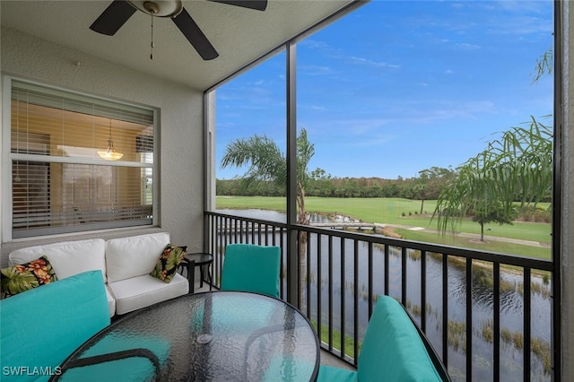 sunroom / solarium with a water view and ceiling fan