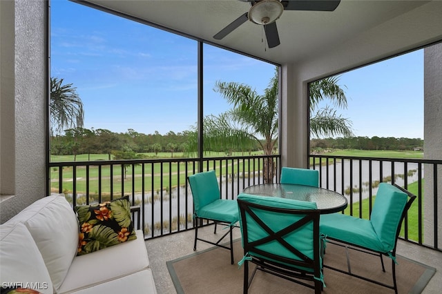 sunroom with a water view and ceiling fan