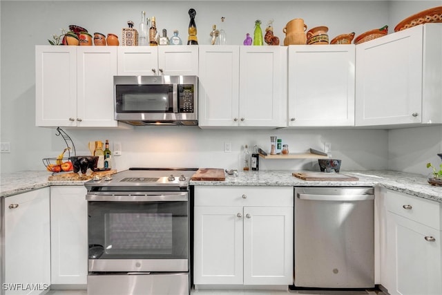 kitchen with white cabinetry, light stone countertops, and appliances with stainless steel finishes