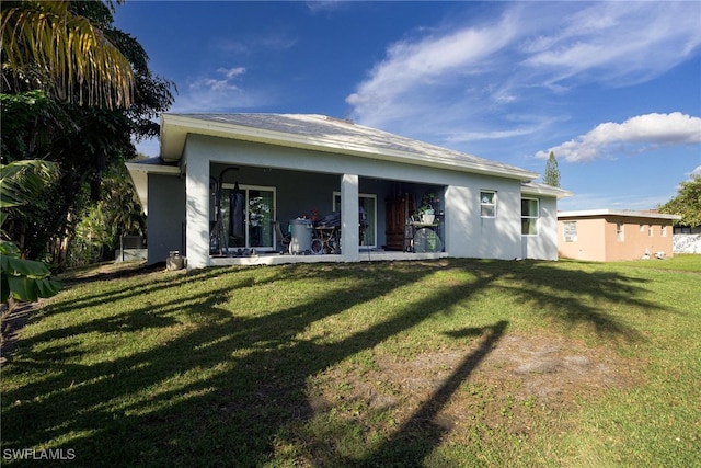 rear view of property featuring a yard