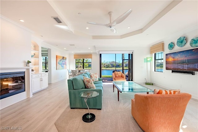 living room featuring light hardwood / wood-style floors, ceiling fan, and ornamental molding