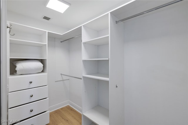walk in closet featuring light wood-type flooring and visible vents