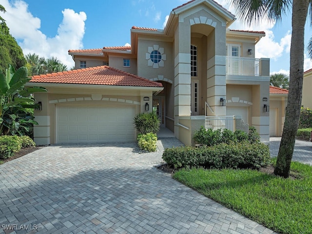 26831 Wyndhurst Ct Unit 101, Bonita Springs, FL 34134 - mediterranean / spanish home featuring a tiled roof, stucco siding, decorative driveway, and a garage