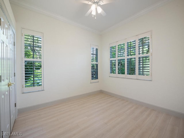 empty room with ceiling fan, plenty of natural light, crown molding, and light hardwood / wood-style floors