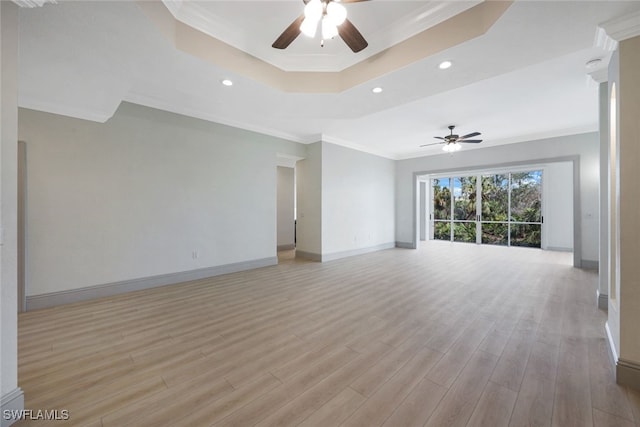 unfurnished living room with ceiling fan, a tray ceiling, ornamental molding, and light hardwood / wood-style floors