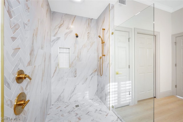 bathroom featuring wood-type flooring and tiled shower