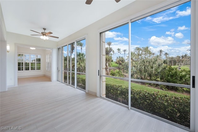 unfurnished sunroom with ceiling fan