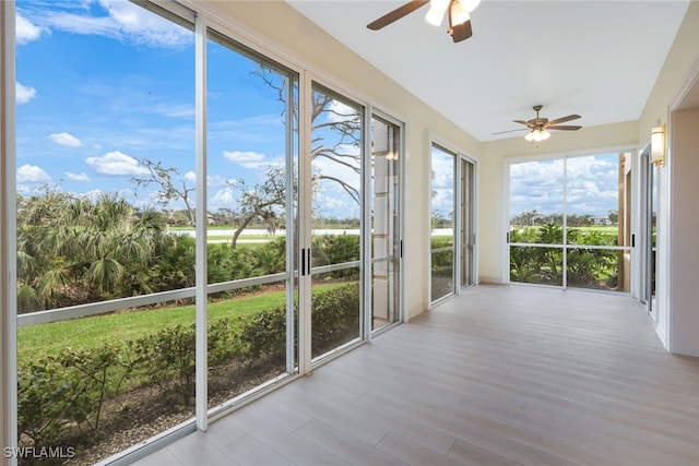 unfurnished sunroom featuring ceiling fan