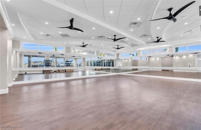 gym featuring hardwood / wood-style flooring and a towering ceiling