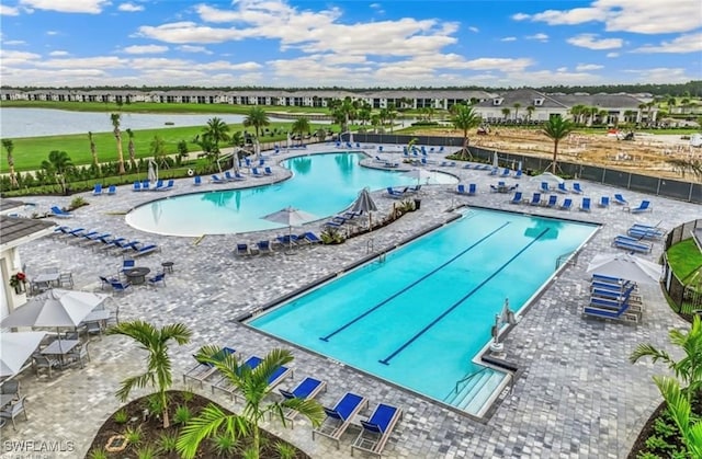 view of pool with a water view and a patio area