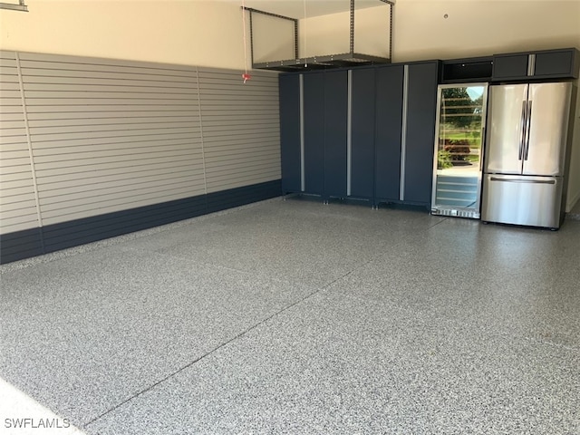 garage with beverage cooler and stainless steel fridge