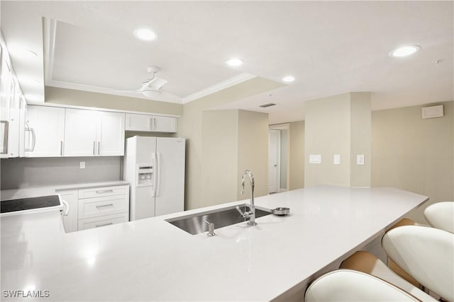 kitchen with crown molding, a sink, white cabinets, a peninsula, and white appliances
