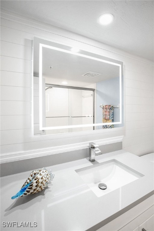 bathroom with ornamental molding and vanity