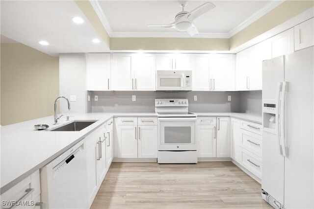 kitchen featuring a sink, white cabinets, ornamental molding, recessed lighting, and white appliances