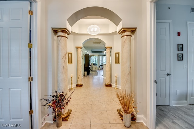 hall featuring light hardwood / wood-style flooring and decorative columns