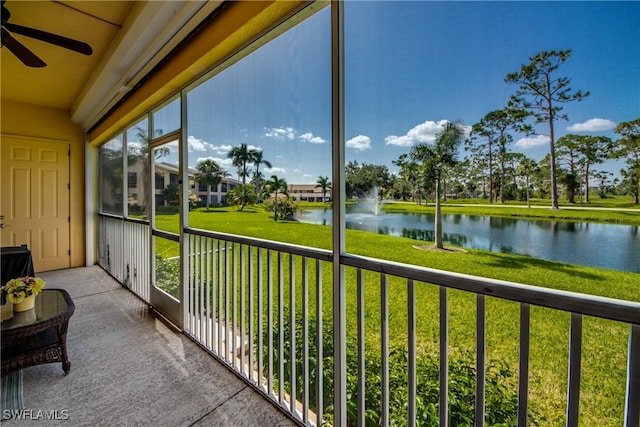 sunroom / solarium featuring a water view and ceiling fan