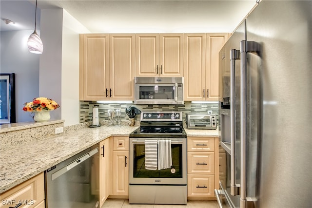 kitchen featuring appliances with stainless steel finishes, pendant lighting, and light brown cabinets