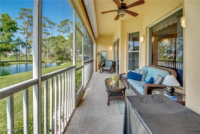 sunroom / solarium with ceiling fan and a water view