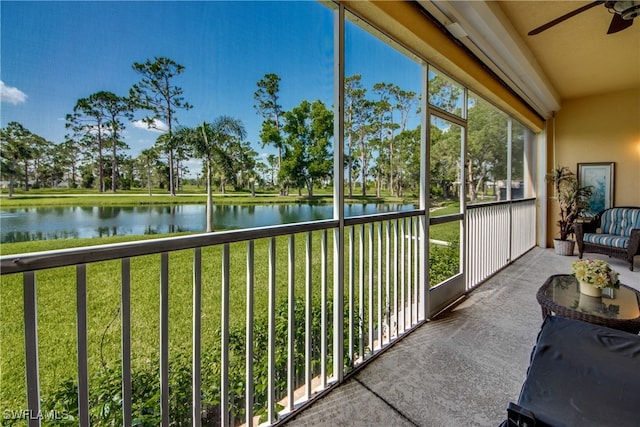 unfurnished sunroom featuring a water view and ceiling fan