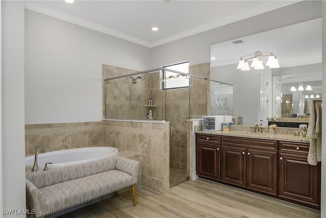 bathroom featuring hardwood / wood-style floors, vanity, separate shower and tub, and ornamental molding