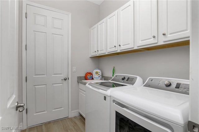 laundry room featuring separate washer and dryer, cabinets, and light wood-type flooring