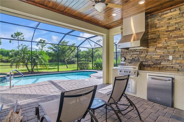 view of pool featuring ceiling fan, grilling area, a patio area, and exterior kitchen