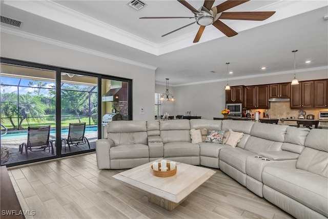 living room featuring crown molding, ceiling fan with notable chandelier, and light wood-type flooring